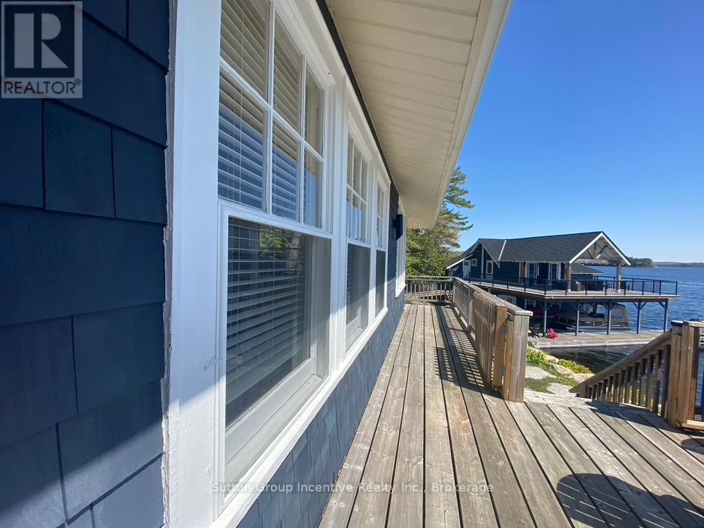 A wooden deck leads to a house with a blue exterior.