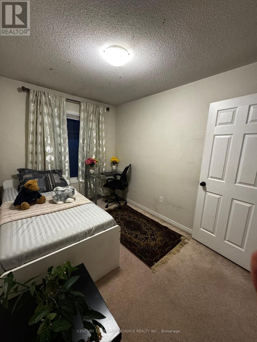 A bedroom with a bed, a chair, and a door.