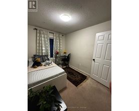 A bedroom with a bed, a chair, and a door.