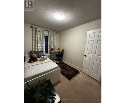 A bedroom with a bed, a chair, and a door.