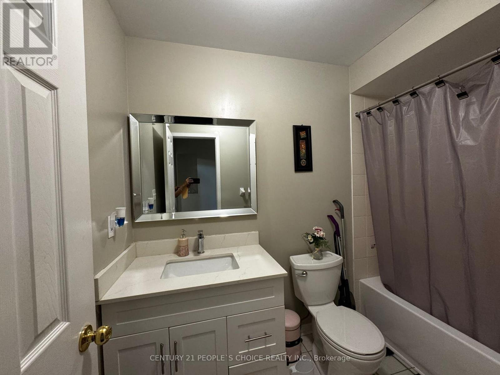 A bathroom with a sink, toilet, and a mirror.