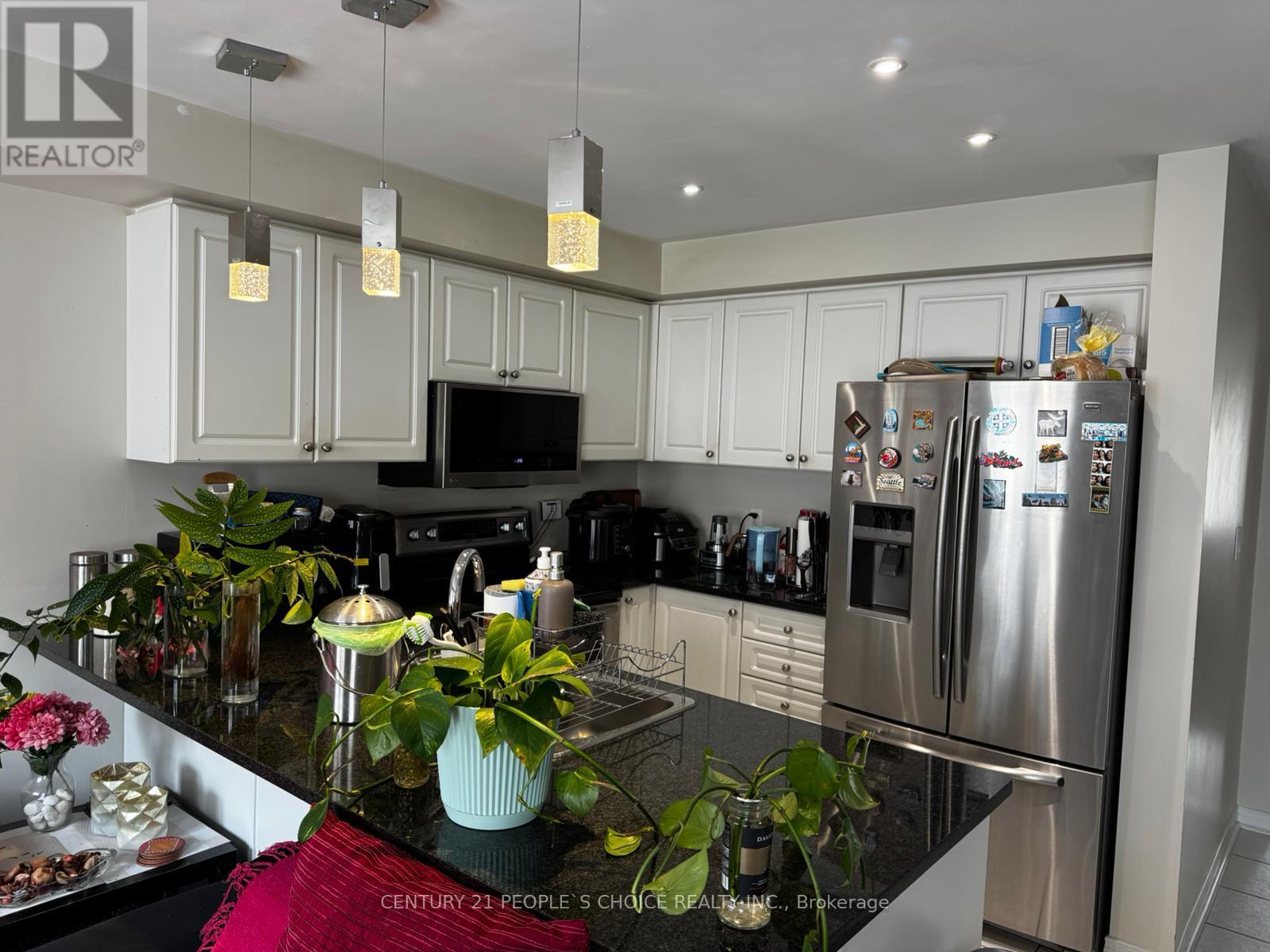 A kitchen with a black granite counter top and stainless steel appliances.