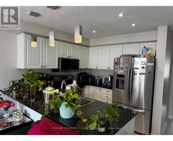 A kitchen with a black granite counter top and stainless steel appliances.