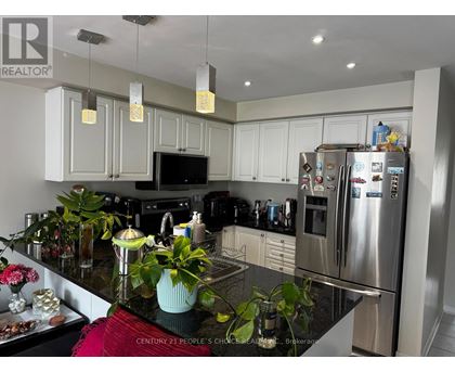 A kitchen with a black granite counter top and stainless steel appliances.