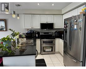 A kitchen with a black counter top and stainless steel appliances.
