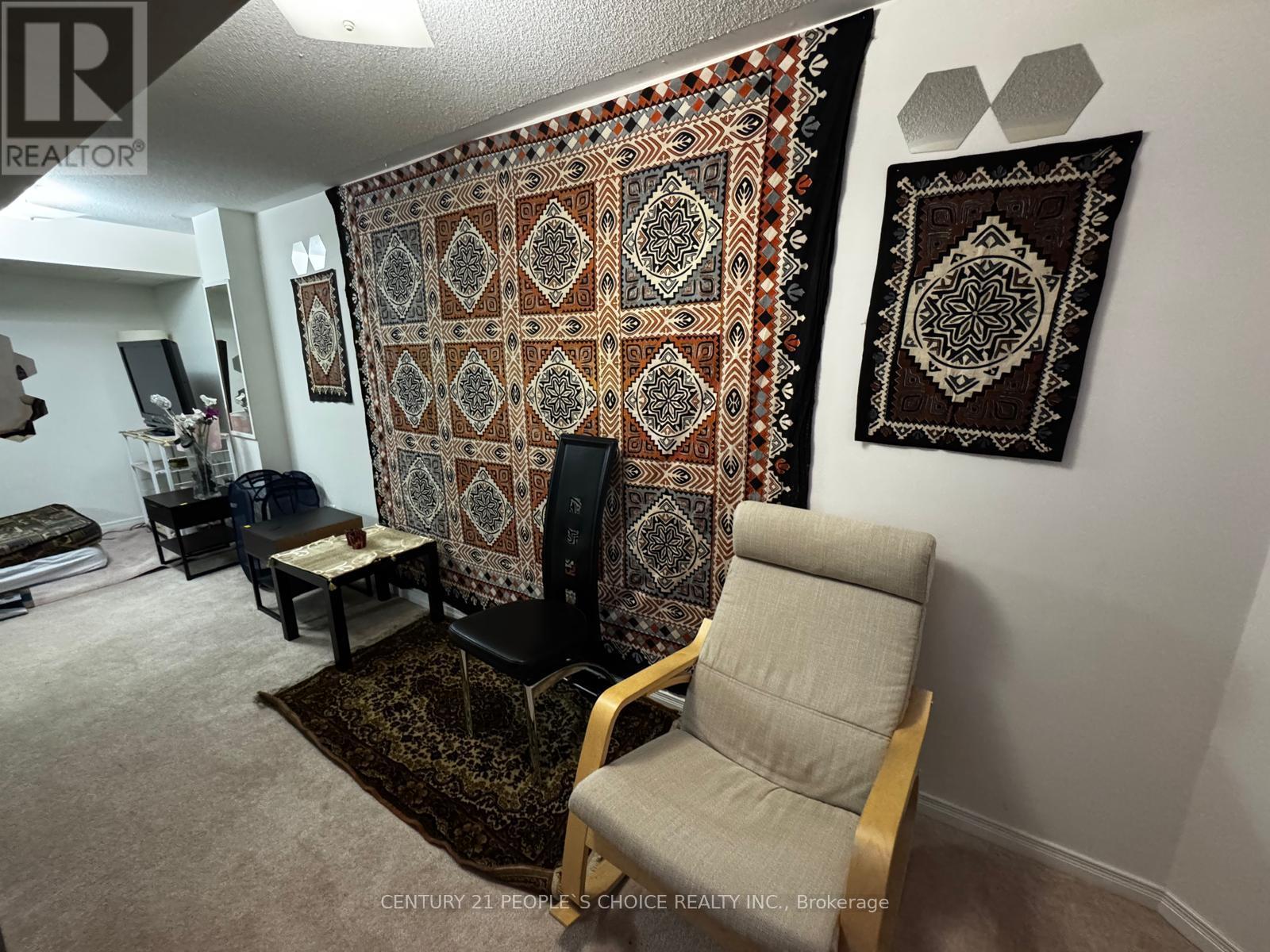 A living room with a large tapestry hanging on the wall.