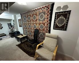 A living room with a large tapestry hanging on the wall.
