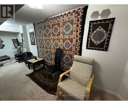 A living room with a large tapestry hanging on the wall.