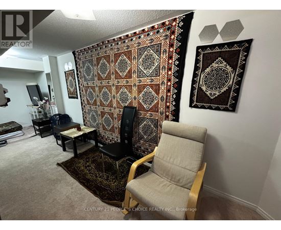A living room with a large tapestry hanging on the wall.
