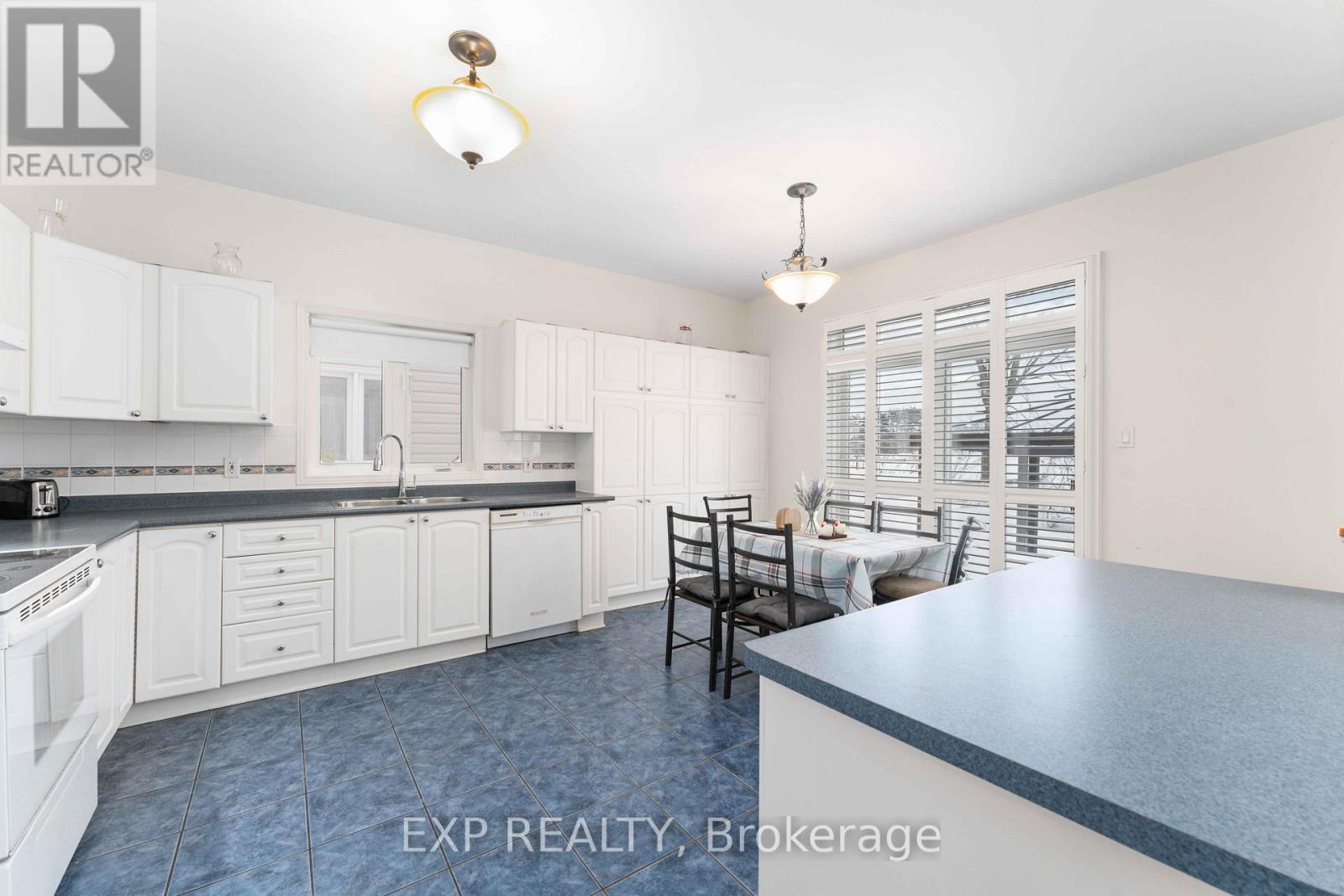 A kitchen with white cabinets and a blue counter.