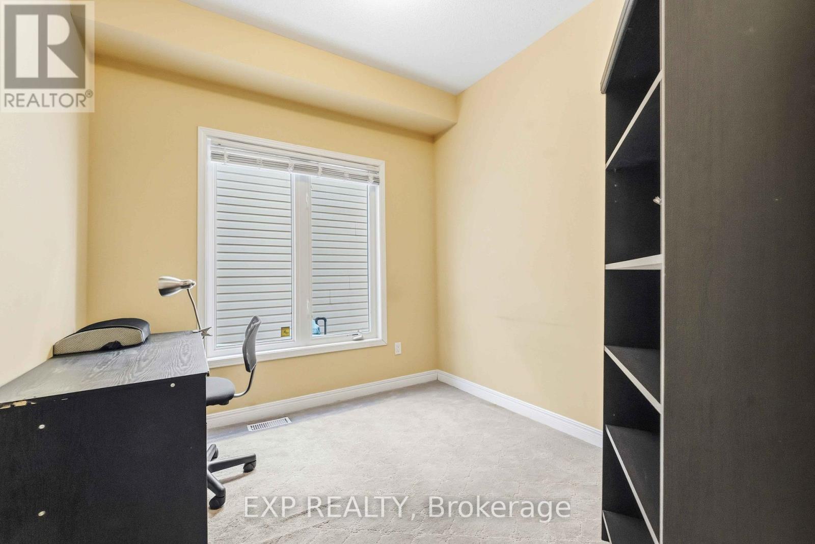 A bedroom with a large bed and a carpeted floor.