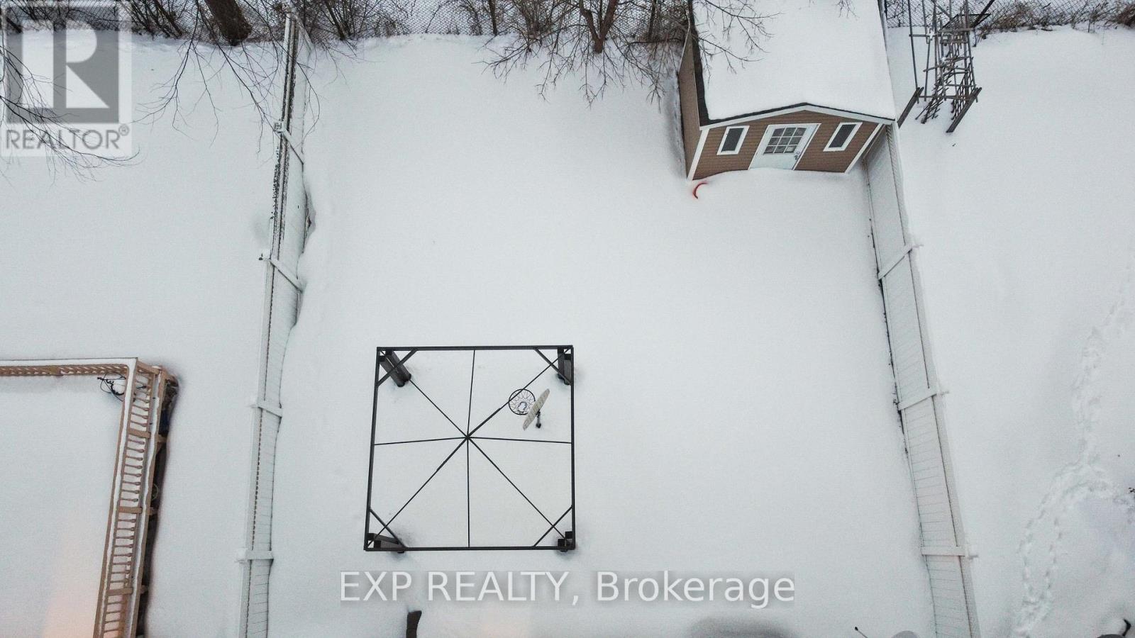 A house is hanging off the side of a building covered in snow.