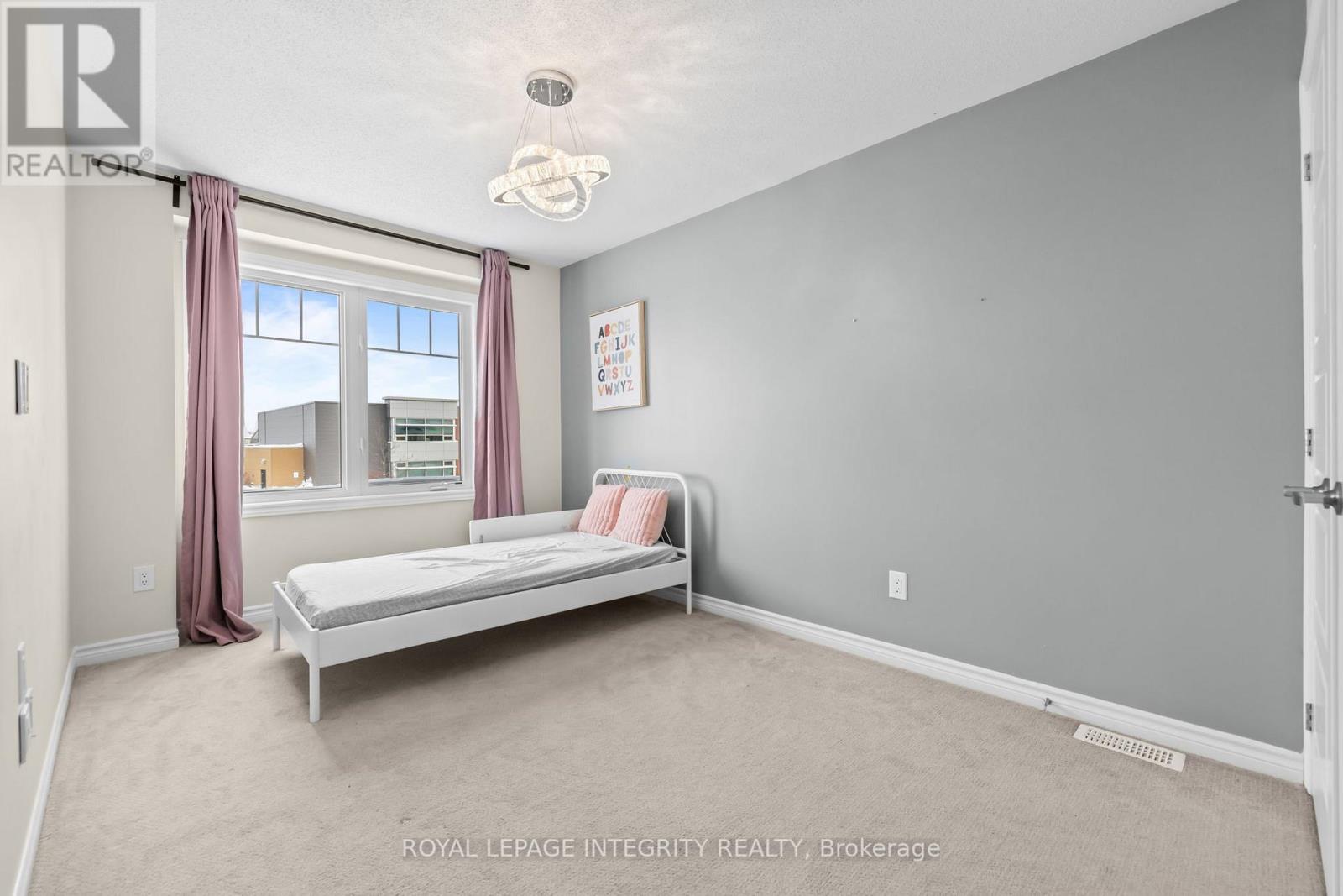 A bedroom with a bed, window, and curtains.