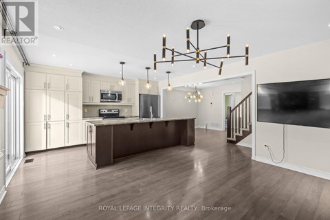 A spacious kitchen with a dark wood floor and a large island.
