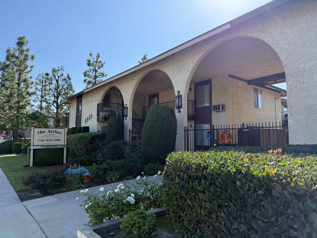 The front of a building called The Arches with a sign in front of it.