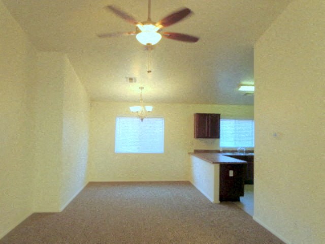 an empty living room with a ceiling fan