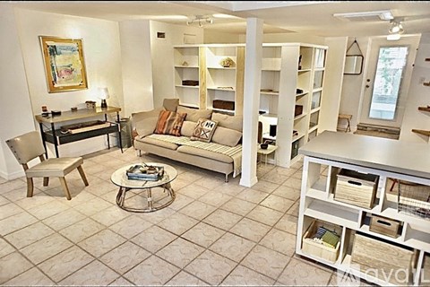 A living room with a couch, coffee table, and a painting on the wall.