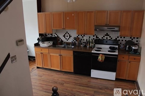 A kitchen with wooden cabinets and black and white tiles.