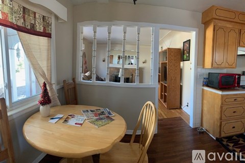 A dining room with a wooden table and chairs.