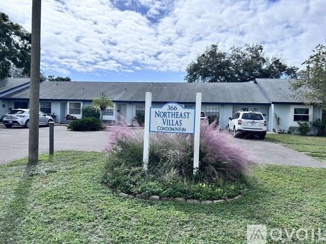 A sign for Northeast Villas Condominium stands in front of a building.