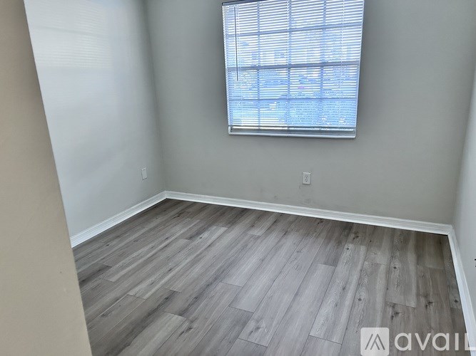 A room with a window and wooden flooring.