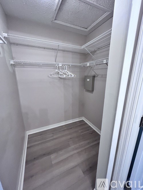 A white closet with a wooden floor and a white ceiling.