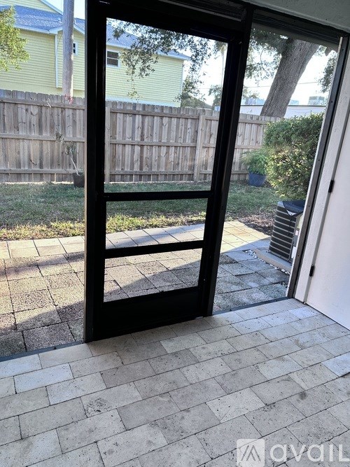 A patio door with a black frame and a view of a backyard.