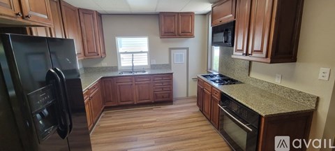 A kitchen with wooden cabinets and granite countertops is available.