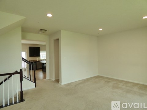 A spacious living room with a television and a staircase leading to the upper floor.