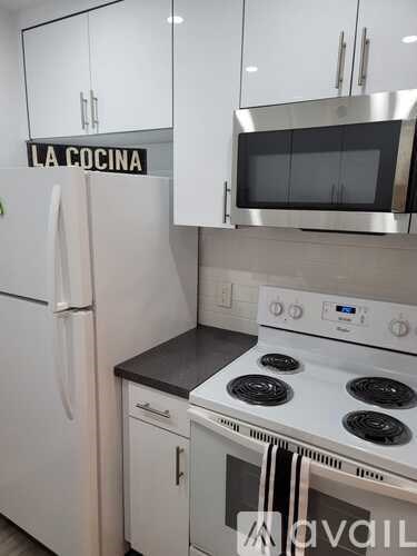 A kitchen with a stove top oven and a refrigerator.