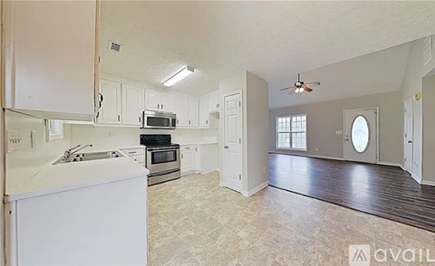 A kitchen with white cabinets and a white island.