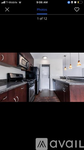 A kitchen with dark wood cabinets and a white refrigerator.