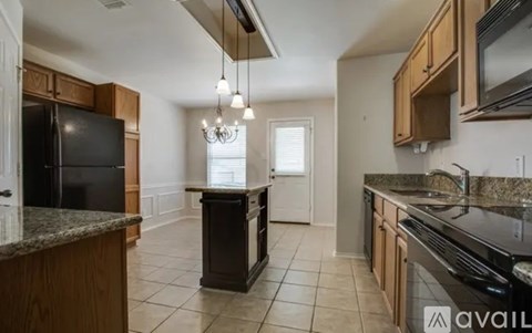 A kitchen with black appliances and wooden cabinets.