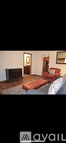 A living room with a red couch and a wooden coffee table.