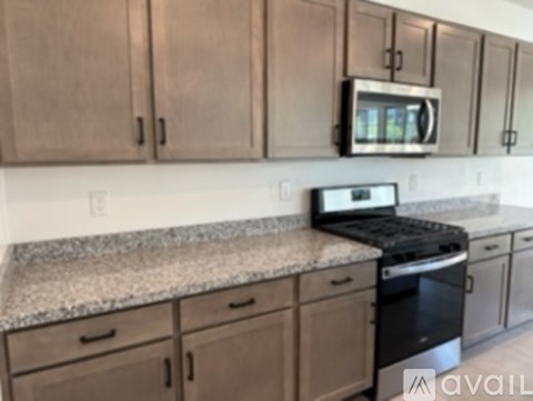 A kitchen with a black oven and microwave above it.