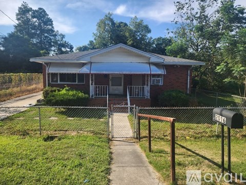 A house with a white roof and a mailbox with the number 2016 on it.