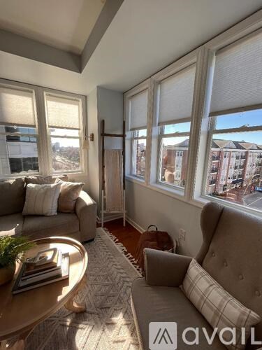 A living room with a couch, chair, and table with a plant on it.