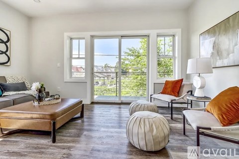 A living room with a brown leather sofa and a grey couch with a white cushion.