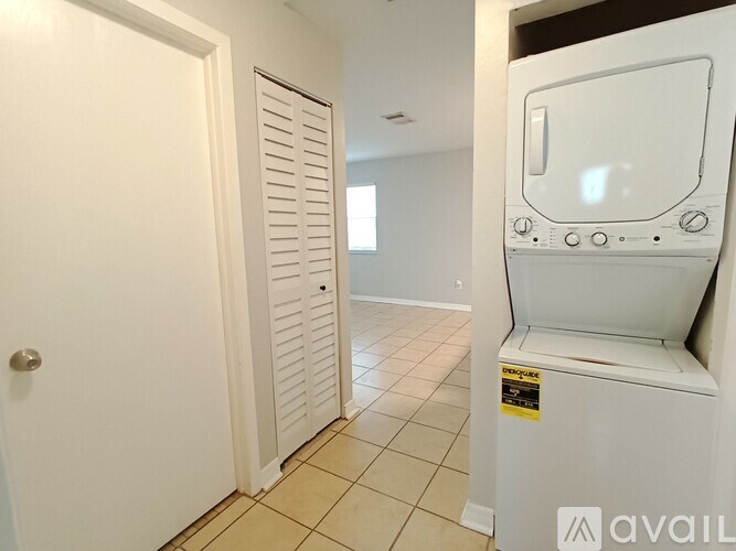 A white refrigerator is in a kitchen with a white door.