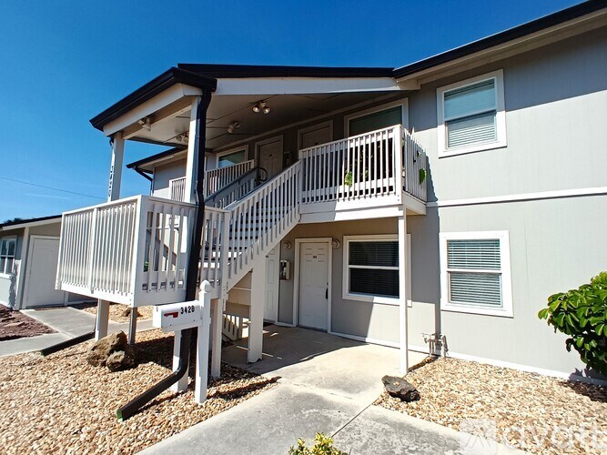 A two-story house with a balcony and a small garden in front.