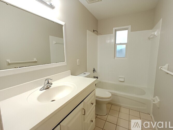 A white bathroom with a sink, toilet, and bathtub.