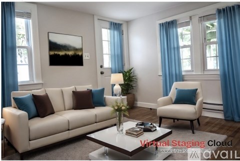 A living room with a white couch, a coffee table, and a painting on the wall.