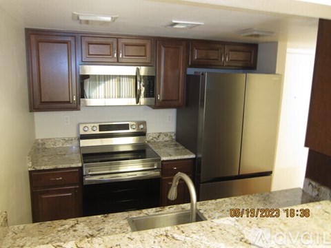 A kitchen with a stove top oven and a refrigerator.