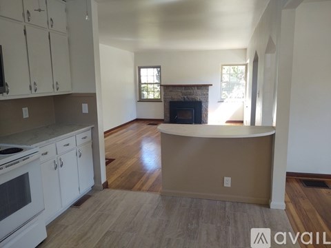 A kitchen with white cabinets and a wooden floor.