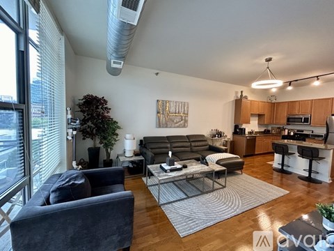 A living room with a grey sofa and a glass table.