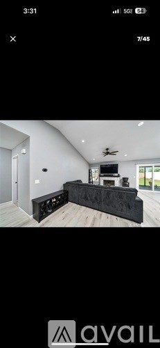 A modern living room with a black sofa and a television.