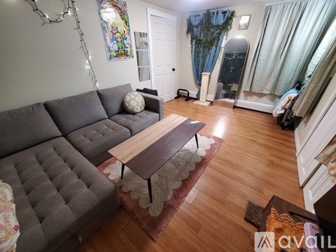 A living room with a grey sofa and a wooden coffee table.