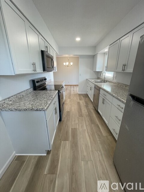 A kitchen with white cabinets and a granite countertop.