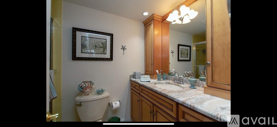 A bathroom with a toilet, sink, and mirror.