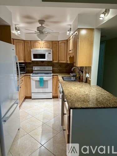 A kitchen with granite countertops and a tile floor.